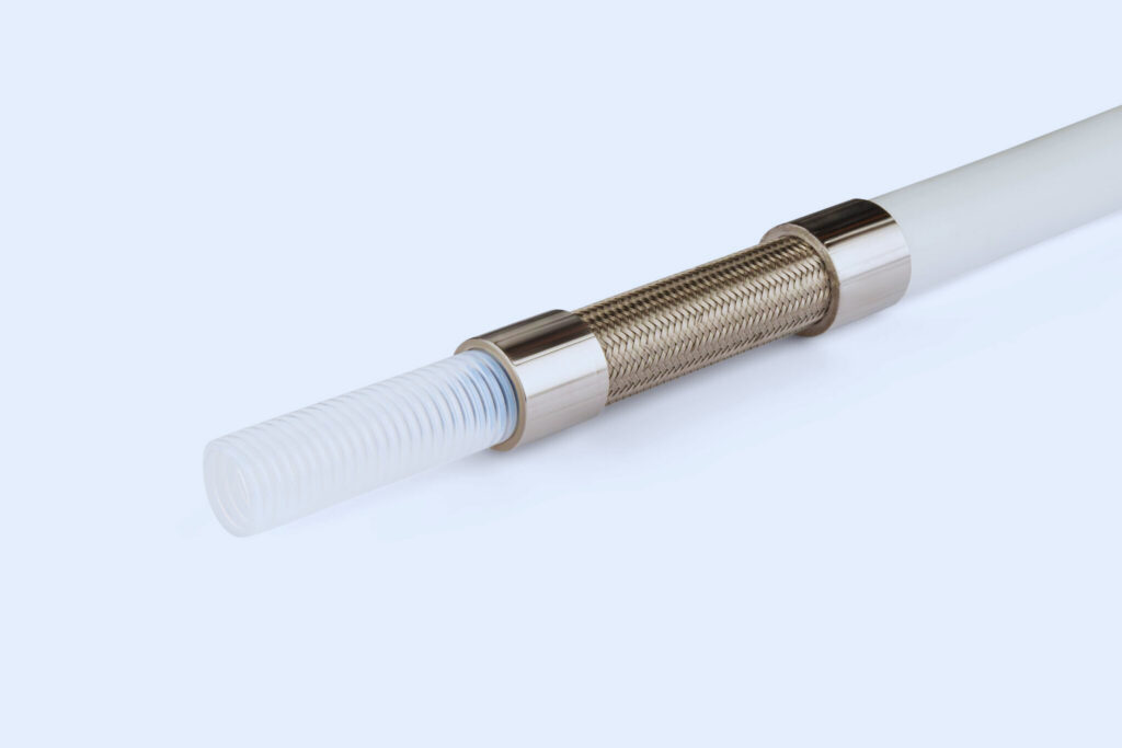 Nærbillede af PTFE-slange med rustfri stålfletning og metalforbindelser til industrielle processer.
